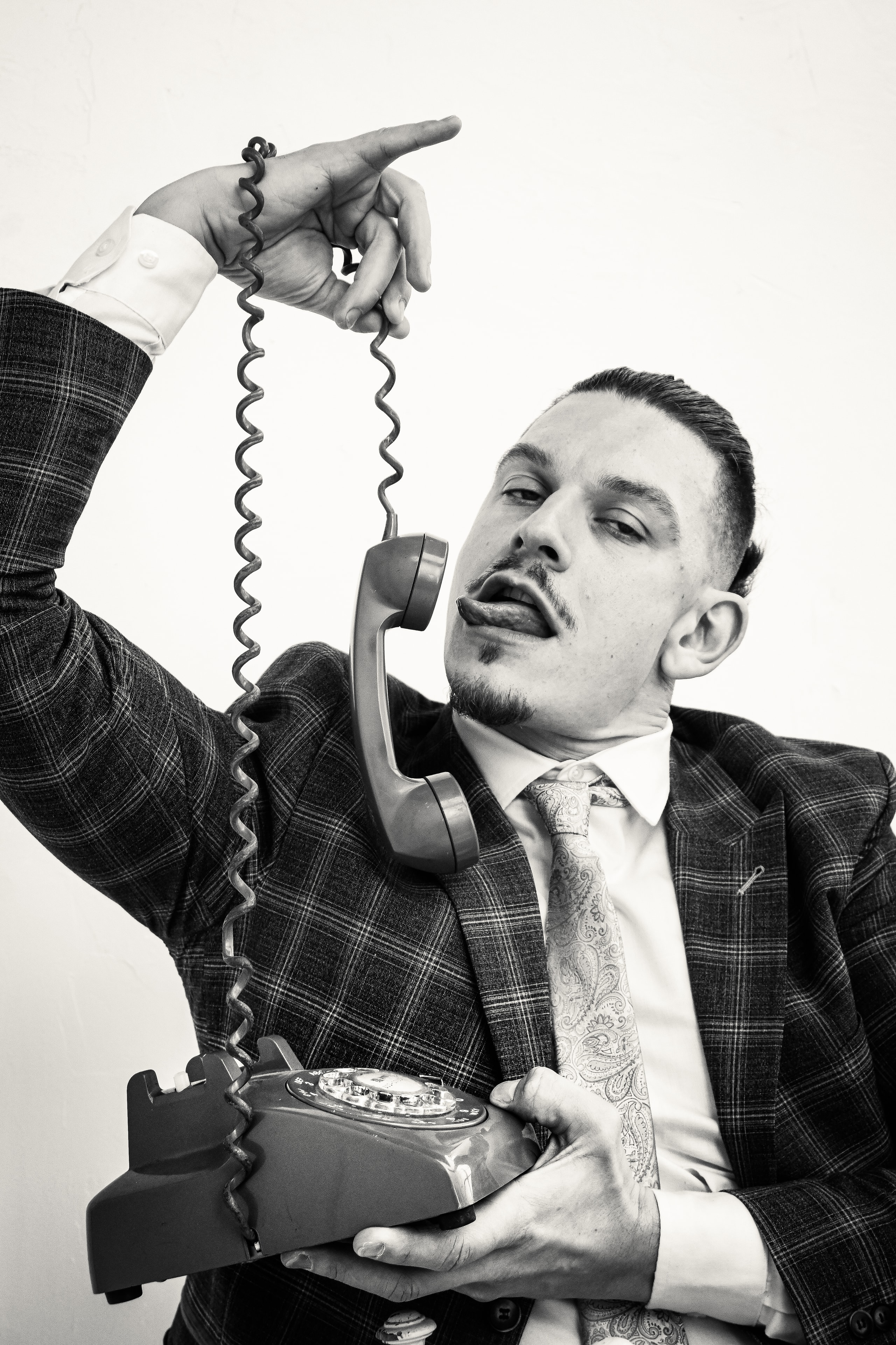 Businessman with vintage telephone cord, editorial portrait